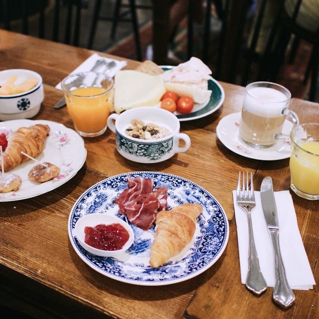 Ontbijttafel met croissants, jus d’orange en koffie in Café Jolie